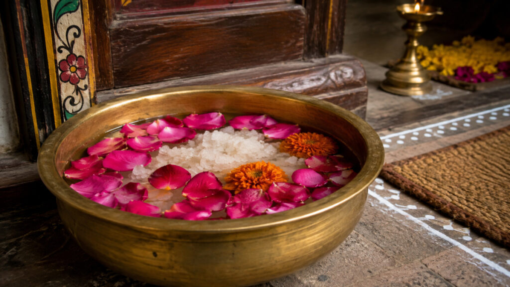 Brass bowl with sea salt and fresh flowers placed at house entrance for positive energy.